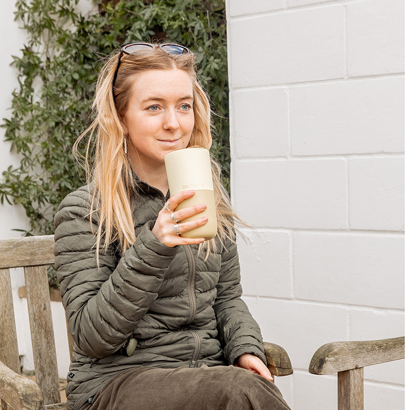 16oz-rise-tumbler-y6 16oz_rise_tumbler_wax_yellow_woman_seat_outside_square.jpg