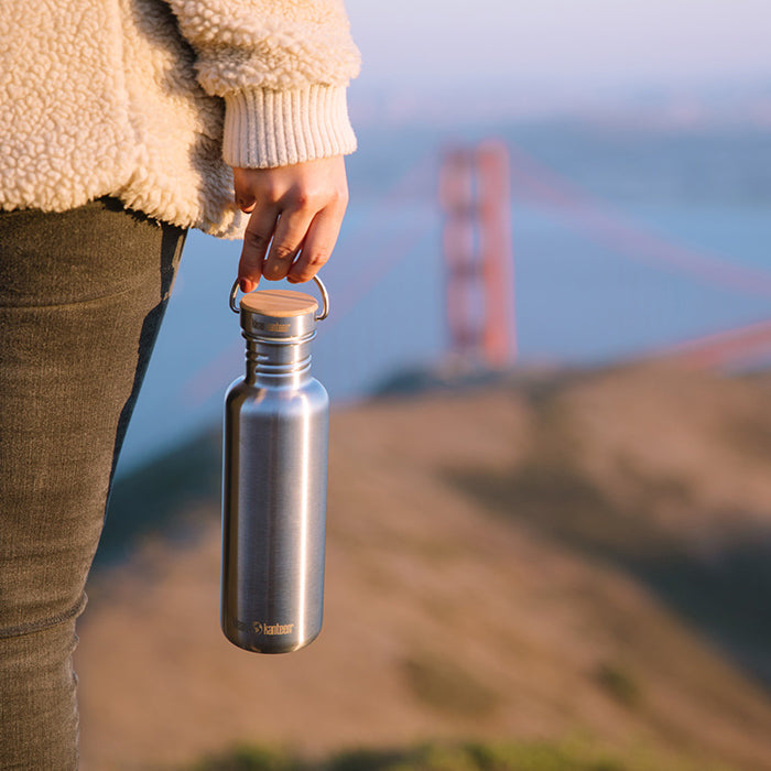 27oz-reflect-with-bamboo-cap-i3 K27SSLRF-BS-BAMBOO_reflect_bottle_bridge_lifestyle.jpg